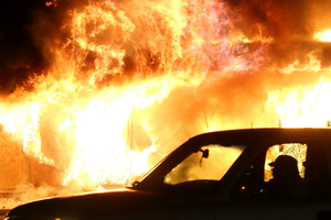 A car drives by a burning building during a demonstration on Nov. 24 in Ferguson, Mo. A car drives by a burning building during a demonstration on Nov. 24 in Ferguson, Mo.