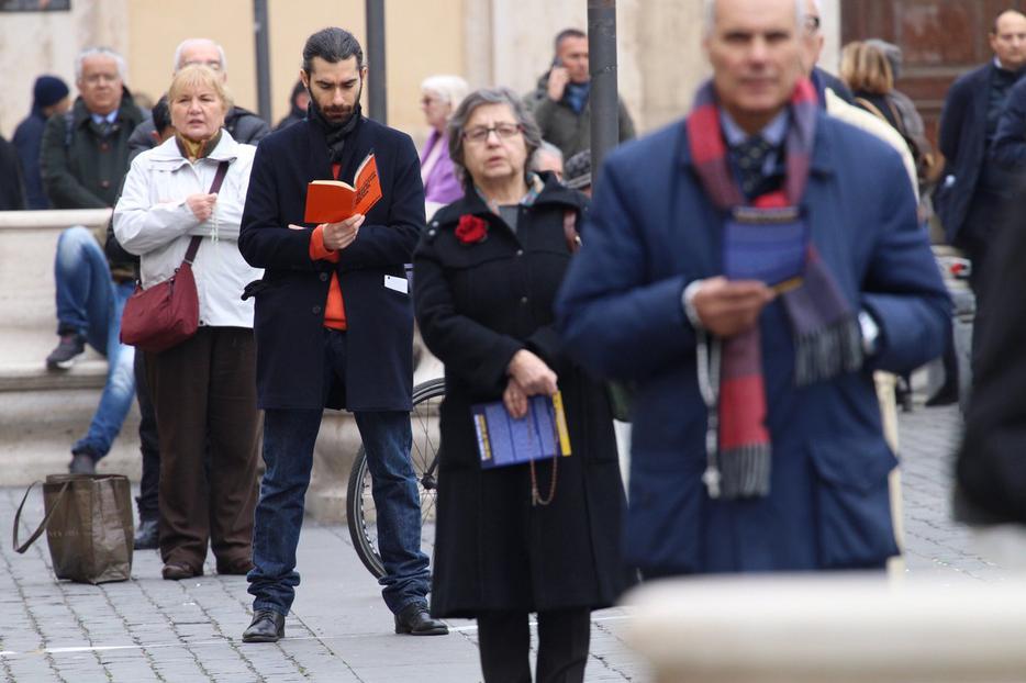 A protester reads a devotional book alongside others taking part in the 'break the silence' demonstration in Rome, Feb. 19; top to bottom: scenes from the demonstration, press conference. A protester reads a devotional book alongside others taking part in the 'break the silence' demonstration in Rome, Feb. 19; top to bottom: scenes from the demonstration, press conference.