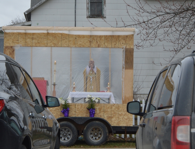 Father Michael Klos celebrates a drive-in Mass on Easter Sunday 2020 in the Sacred Heart Church parking lot in Cashton, Wisconsin. Father Michael Klos celebrates a drive-in Mass on Easter Sunday 2020 in the Sacred Heart Church parking lot in Cashton, Wisconsin.