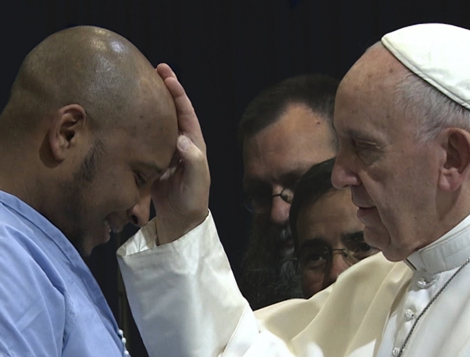 Above, footage of Pope Francis blessing an inmate from Pope Francis: A Man of His Word. Below, director Wim Wenders and Pope Francis. Above, footage of Pope Francis blessing an inmate from Pope Francis: A Man of His Word. Below, director Wim Wenders and Pope Francis.