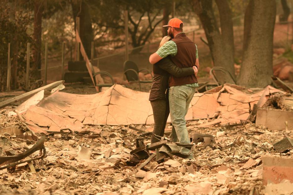 Above, Chris and Nancy Brown embrace Nov. 12 while looking over the remains of their burned residence after the Camp Fire tore through the region in Paradise, California. Below, Alameda County Sheriff Coroner officers search for human remains at a burned residence in Paradise on Nov. 12, and a welcome sign remains near a burned residence in Paradise. Above, Chris and Nancy Brown embrace Nov. 12 while looking over the remains of their burned residence after the Camp Fire tore through the region in Paradise, California. Below, Alameda County Sheriff Coroner officers search for human remains at a burned residence in Paradise on Nov. 12, and a welcome sign remains near a burned residence in Paradise.