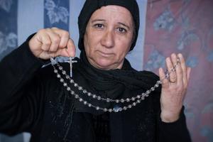 A displaced Iraqi-Christian woman from Qaraqosh displays her most prized possession last month in her tented home located on the grounds of Mar Elia Catholic Church in Erbil, Iraq. A displaced Iraqi-Christian woman from Qaraqosh displays her most prized possession last month in her tented home located on the grounds of Mar Elia Catholic Church in Erbil, Iraq.