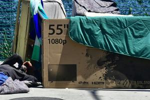 A homeless man sleeps beside his makeshift temporary shelter on a street in downtown Los Angeles June 25.
A homeless man sleeps beside his makeshift temporary shelter on a street in downtown Los Angeles June 25.