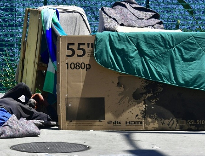 A homeless man sleeps beside his makeshift temporary shelter on a street in downtown Los Angeles June 25.
A homeless man sleeps beside his makeshift temporary shelter on a street in downtown Los Angeles June 25.