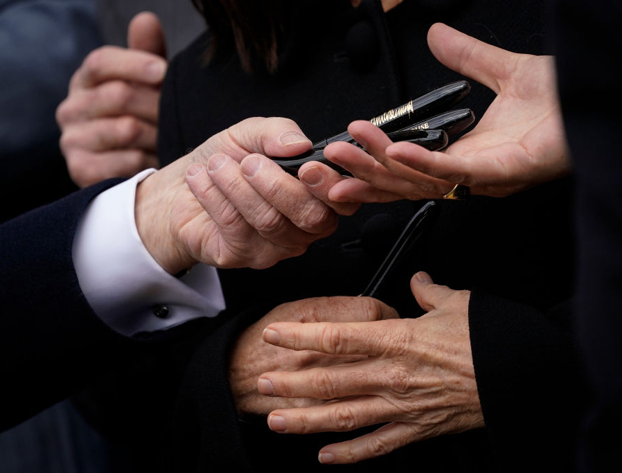 President Donald Trump hands out pens to lawmakers after a Jan. 29 signing ceremony at the White House. President Donald Trump hands out pens to lawmakers after a Jan. 29 signing ceremony at the White House.