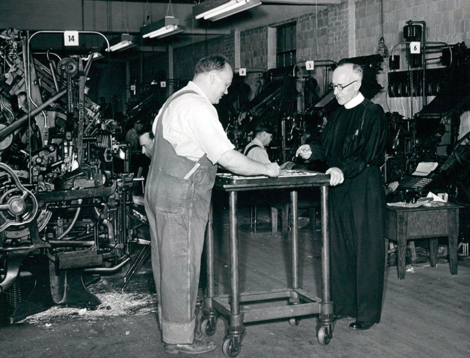 National Catholic Register founding editor Msgr. Matthew Smith (R) reviews an issue in the Register’s mid-century print facility. National Catholic Register founding editor Msgr. Matthew Smith (R) reviews an issue in the Register’s mid-century print facility.