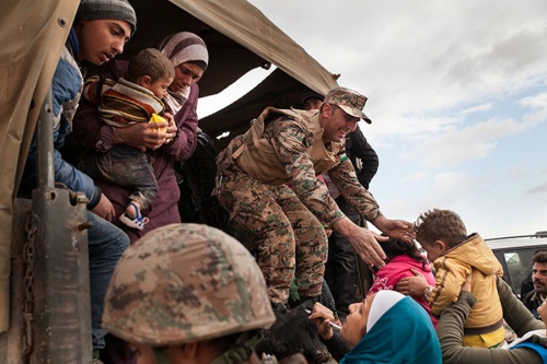 Jordanian troops and U.N. members help bring refugees to the Zaatari refugee camp. Jordanian troops and U.N. members help bring refugees to the Zaatari refugee camp.
