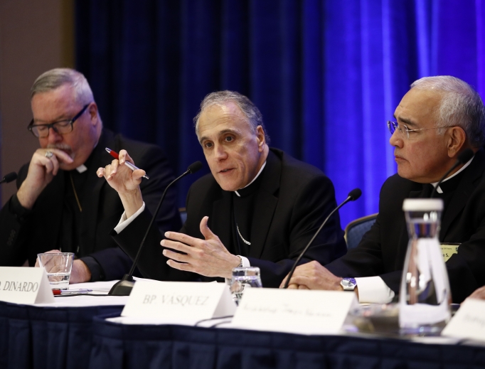 Above, Cardinal Daniel DiNardo of the Archdiocese of Galveston-Houston (c), the president of the U.S. Conference of Catholic Bishops, speaks at a news conference flanked by Bishop Christopher Coyne of Burlington, Vermont (l), and Bishop Joe Vasquez of Austin, Texas, during the USCCB's annual fall meeting in Baltimore Nov. 13. Below, the bishops gather at Mass at the Baltimore basilica. Above, Cardinal Daniel DiNardo of the Archdiocese of Galveston-Houston (c), the president of the U.S. Conference of Catholic Bishops, speaks at a news conference flanked by Bishop Christopher Coyne of Burlington, Vermont (l), and Bishop Joe Vasquez of Austin, Texas, during the USCCB's annual fall meeting in Baltimore Nov. 13. Below, the bishops gather at Mass at the Baltimore basilica.