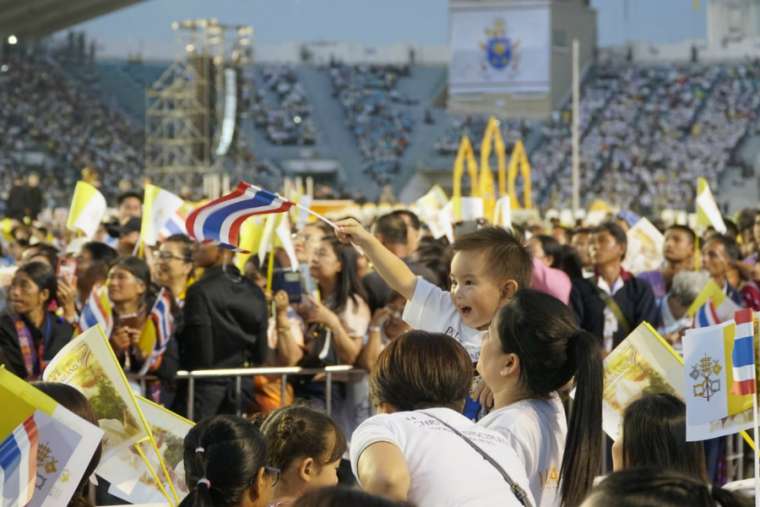 A young boy waves a Thai flag before Mass with Pope Francis in Bangkok. A young boy waves a Thai flag before Mass with Pope Francis in Bangkok.