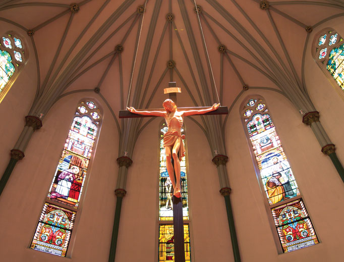 Above, the Crucified Christ above the new altar, while (below) the old altar highlights an elaborate Victorian Gothic style and an icon of the Holy Family and the current sanctuary draw the faithful to prayer. Above, the Crucified Christ above the new altar, while (below) the old altar highlights an elaborate Victorian Gothic style and an icon of the Holy Family and the current sanctuary draw the faithful to prayer.