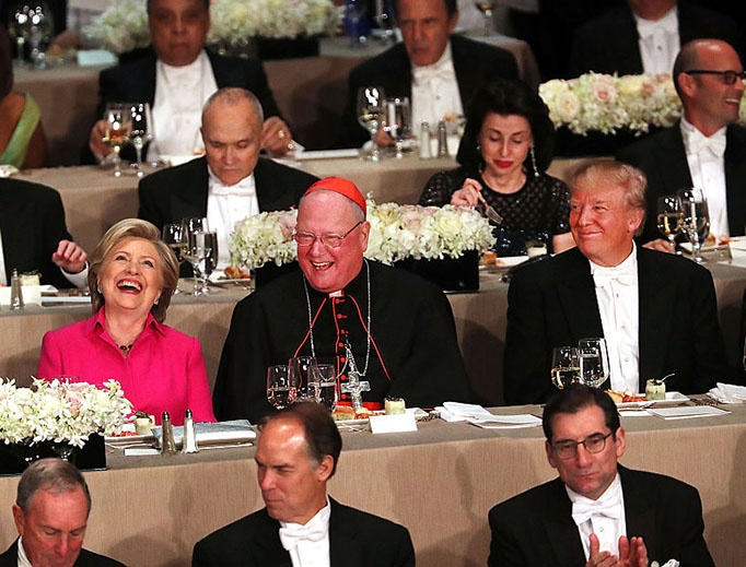Cardinal Timothy Dolan sits between Hillary Clinton and Donald Trump at the annual Alfred E. Smith Memorial Foundation Dinner at the Waldorf Astoria on October 20, 2016 in New York City. Cardinal Timothy Dolan sits between Hillary Clinton and Donald Trump at the annual Alfred E. Smith Memorial Foundation Dinner at the Waldorf Astoria on October 20, 2016 in New York City.
