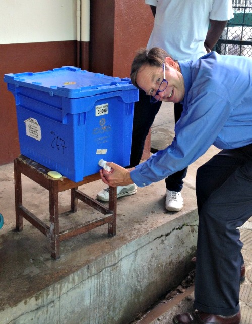 Dr./Deacon Timothy Flanigan sanitizes his hands at a Liberia medical clinic. Dr./Deacon Timothy Flanigan sanitizes his hands at a Liberia medical clinic.
