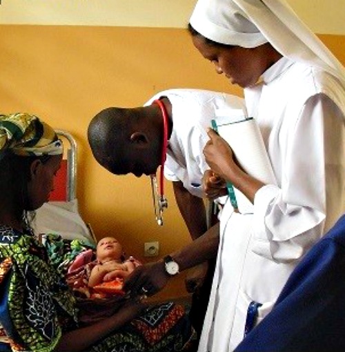 Camillian Father Bernard Kinvi visits a mother and child at John Paul II Hospital in the Central African Republic.
Camillian Father Bernard Kinvi visits a mother and child at John Paul II Hospital in the Central African Republic.