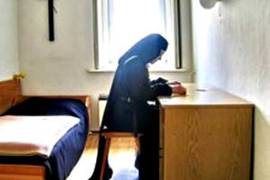 A Carmelite nun meditates on the Bible in her room. A Carmelite nun meditates on the Bible in her room.