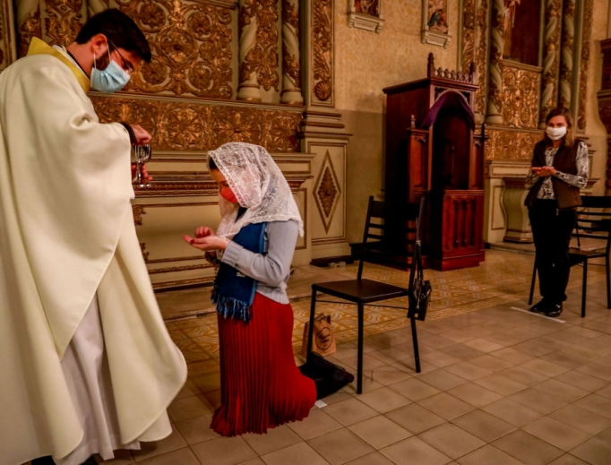 Father Lucas Mendes, wearing a protective face mask, gives Holy Communion to a worshipper during Mass at the Nossa Senhora das Dores Church in Porto Alegre, in southern Brazil, on May 29. American infectious-disease experts say that going to Mass is one of the safest activities amid the pandemic. Father Lucas Mendes, wearing a protective face mask, gives Holy Communion to a worshipper during Mass at the Nossa Senhora das Dores Church in Porto Alegre, in southern Brazil, on May 29. American infectious-disease experts say that going to Mass is one of the safest activities amid the pandemic.