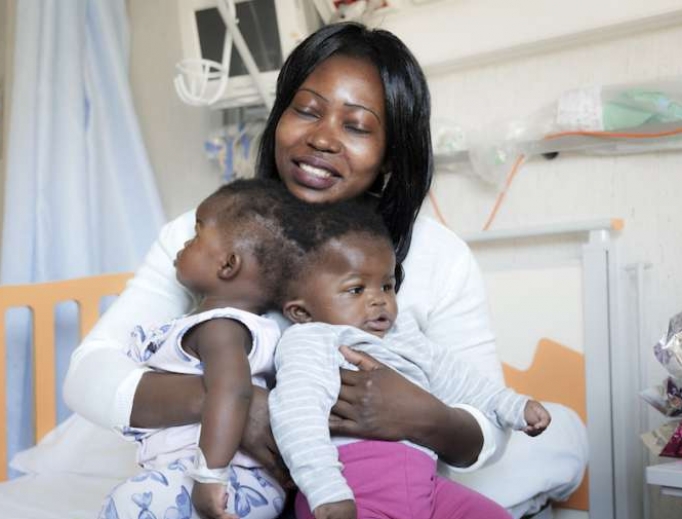 Ermine, mother of the twins holds her babies at the hospital. Ermine, mother of the twins holds her babies at the hospital.