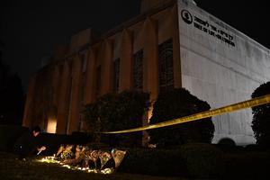 A man kneels to light a candle beneath a police cordon outside the Tree of Life Synagogue after a shooting there left 11 people dead in the Squirrel Hill neighborhood of Pittsburgh Oct. 27. A man kneels to light a candle beneath a police cordon outside the Tree of Life Synagogue after a shooting there left 11 people dead in the Squirrel Hill neighborhood of Pittsburgh Oct. 27.