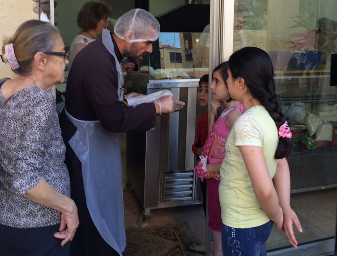 Above, Father Majdi Allawi, founder of Lebanese Charity Bonheur du Ciel ("Heaven's Joy"), greets children at the organization's free bakery for the poor.
Below: Father Allawi prays in the chapel at the organization's free supermarket for the poor and sweeps the floor at the organization's free salon for the poor. Above, Father Majdi Allawi, founder of Lebanese Charity Bonheur du Ciel ("Heaven's Joy"), greets children at the organization's free bakery for the poor.
Below: Father Allawi prays in the chapel at the organization's free supermarket for the poor and sweeps the floor at the organization's free salon for the poor.