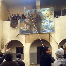 Libyan protesters tear down a sign during a demonstration in the seaport city of Tobruk Feb. 20. Bishop Giovanni Martinelli, the apostolic vicar of Tripoli and the top Church official in Libya, said the country's current unrest was based on legitimate requests by young people for a better future. Libyan protesters tear down a sign during a demonstration in the seaport city of Tobruk Feb. 20. Bishop Giovanni Martinelli, the apostolic vicar of Tripoli and the top Church official in Libya, said the country's current unrest was based on legitimate requests by young people for a better future.