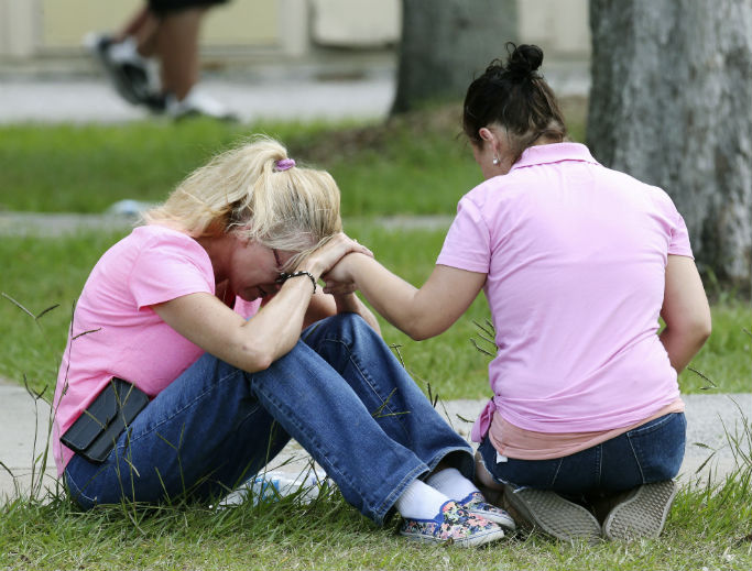 Two women pray outside the family reunification site following a shooting at Santa Fe High School May 18 in Santa Fe, Texas. Two women pray outside the family reunification site following a shooting at Santa Fe High School May 18 in Santa Fe, Texas.