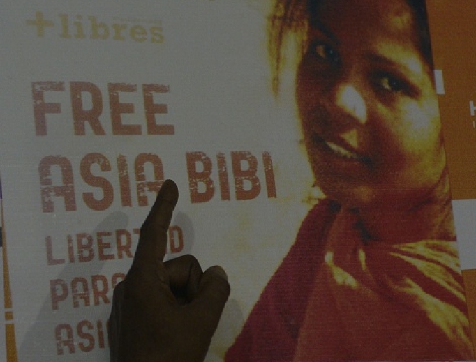 In this photograph taken on Sept. 27, 2016, Ashiq Masih, husband of Asia Bibi, points to a poster bearing an image of Asia.
In this photograph taken on Sept. 27, 2016, Ashiq Masih, husband of Asia Bibi, points to a poster bearing an image of Asia.