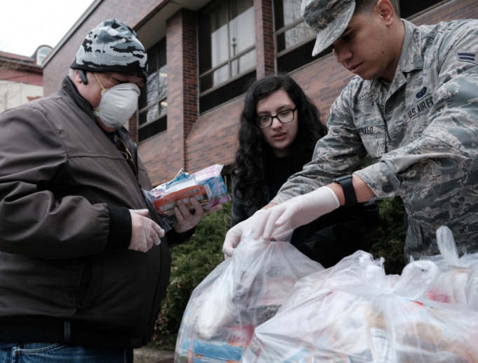 Members of the National Guard hand out bags of food to residents near a 1-mile radius set up to halt the coronavirus (COVID-19) on March 12 in New Rochelle, New York. Members of the National Guard hand out bags of food to residents near a 1-mile radius set up to halt the coronavirus (COVID-19) on March 12 in New Rochelle, New York.