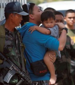 A 2-year-old boy is carried by his father Sept. 17 after a rescue mission by state security forces freed him from Muslim rebels in the southern Philippine city of Zamboanga. A 2-year-old boy is carried by his father Sept. 17 after a rescue mission by state security forces freed him from Muslim rebels in the southern Philippine city of Zamboanga.