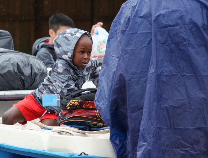 A young boy sits on a boat during rescue operations from flooding due to Hurricane Harvey in Houston. A young boy sits on a boat during rescue operations from flooding due to Hurricane Harvey in Houston.
