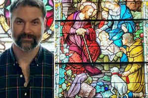 John Scott stands in front of a large stained-glass window at historic Holy Rosary Church in Cedar, Michigan. The right half of the image shows more of the same window. John Scott stands in front of a large stained-glass window at historic Holy Rosary Church in Cedar, Michigan. The right half of the image shows more of the same window.