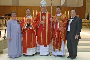 Father Justin (next to his mother) and Father Joshua Waltz (next to his father), shown with their parents, Herb and Theresa. Bishop Paul Zipfel presided at the Cathedral of the Holy Spirit in Bismarck, North Dakota. Below, framed manutergia in the Waltz home: one is behind, showing around the edges. Also shown: Father Jordan Dosch at his first Mass, June 1, at Cathedral of the Holy Spirit, presents the special cloth to his mother, Lynne Dosch. He had just explained the custom before presenting it to his mother. His father, Vernon, is to the left of Lynne.
Father Justin (next to his mother) and Father Joshua Waltz (next to his father), shown with their parents, Herb and Theresa. Bishop Paul Zipfel presided at the Cathedral of the Holy Spirit in Bismarck, North Dakota. Below, framed manutergia in the Waltz home: one is behind, showing around the edges. Also shown: Father Jordan Dosch at his first Mass, June 1, at Cathedral of the Holy Spirit, presents the special cloth to his mother, Lynne Dosch. He had just explained the custom before presenting it to his mother. His father, Vernon, is to the left of Lynne.