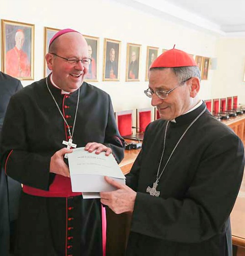 Bishop Carl Demme of Wichita, Kan., presents Father Emil Kapaun's positio to Cardinal Angelo Amato, prefect of Congregation for the Cause of Saints, on Dec. 9 at the Vatican. Bishop Carl Demme of Wichita, Kan., presents Father Emil Kapaun's positio to Cardinal Angelo Amato, prefect of Congregation for the Cause of Saints, on Dec. 9 at the Vatican.