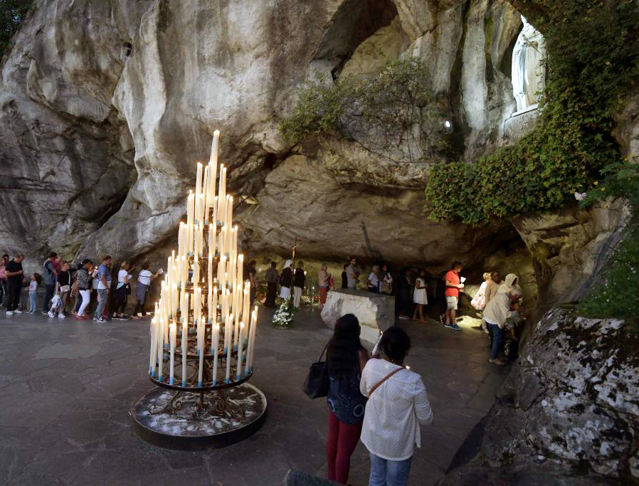 Pilgrims gather Aug. 14, 2019, at the cave in Lourdes where the Blessed Virgin Mary appeared to St. Bernadette Soubirous. Pilgrims gather Aug. 14, 2019, at the cave in Lourdes where the Blessed Virgin Mary appeared to St. Bernadette Soubirous.