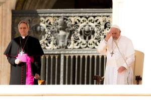 Pope Francis prays, making the Sign of the Cross, at the end of his general audience March 14. Pope Francis prays, making the Sign of the Cross, at the end of his general audience March 14.