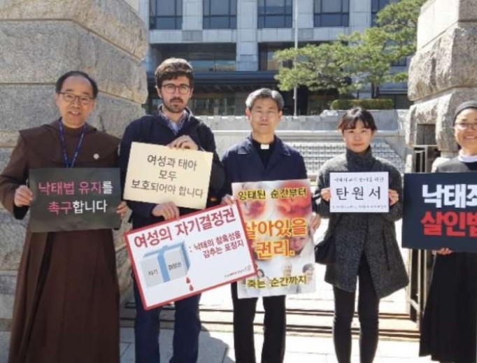 Pro-life activists in South Korea hold signs during the country's March for Life. Pro-life activists in South Korea hold signs during the country's March for Life.