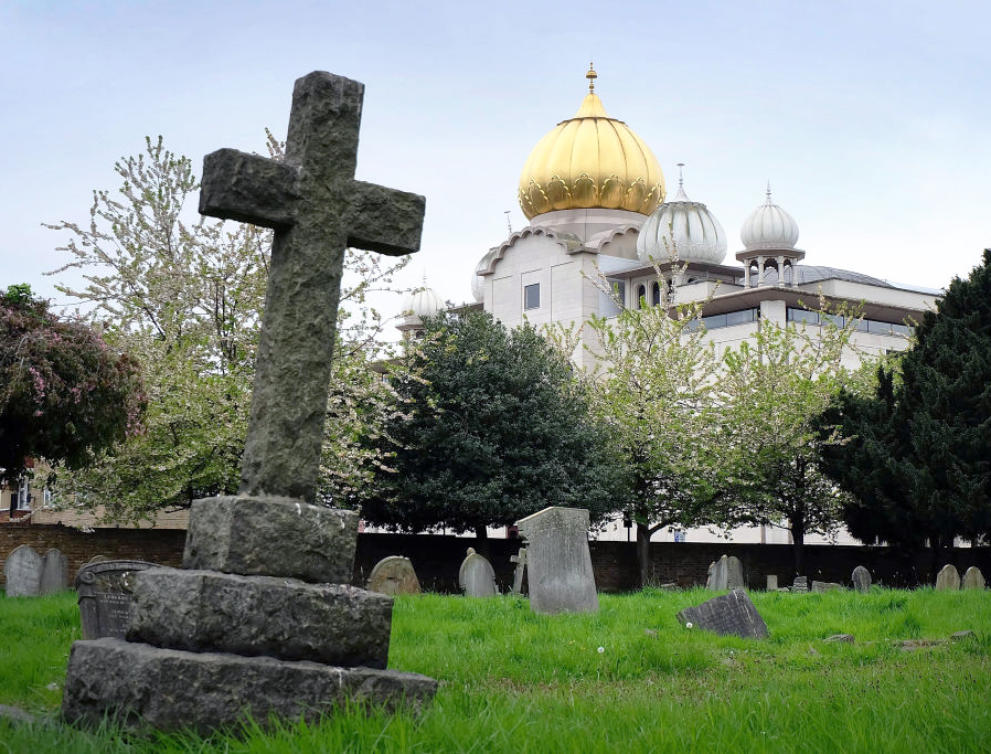 The golden dome of the Sri Guru Singh Sabha Sikh temple in Southall rises up behind the graves of Havelock cemetery, on April 22, 2017 in London, England. The golden dome of the Sri Guru Singh Sabha Sikh temple in Southall rises up behind the graves of Havelock cemetery, on April 22, 2017 in London, England.