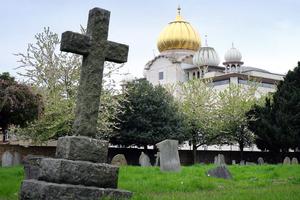 The golden dome of the Sri Guru Singh Sabha Sikh temple in Southall rises up behind the graves of Havelock cemetery, on April 22, 2017 in London, England. The golden dome of the Sri Guru Singh Sabha Sikh temple in Southall rises up behind the graves of Havelock cemetery, on April 22, 2017 in London, England.