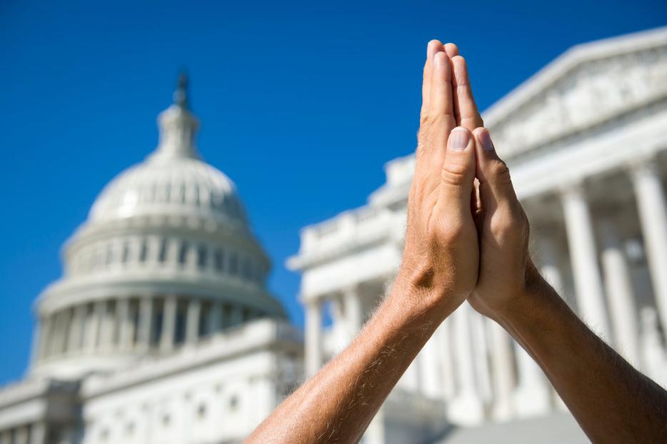 Hands in prayer before the U.S. Capitol building in Washington D.C. Hands in prayer before the U.S. Capitol building in Washington D.C.