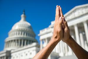 Hands in prayer before the U.S. Capitol building in Washington D.C. Hands in prayer before the U.S. Capitol building in Washington D.C.