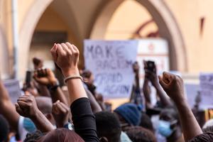 Peaceful demonstrators raise fists and hold signs protesting racism and demanding justice. Peaceful demonstrators raise fists and hold signs protesting racism and demanding justice.