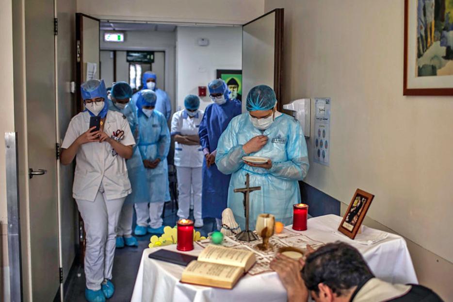 A picture taken by a nurse on May 8 at the Hôtel Dieu de France Hospital in Beirut, Lebanon, shows health workers gathered to attend a Mass offered by a priest in the COVID-19 section of the hospital. A picture taken by a nurse on May 8 at the Hôtel Dieu de France Hospital in Beirut, Lebanon, shows health workers gathered to attend a Mass offered by a priest in the COVID-19 section of the hospital.