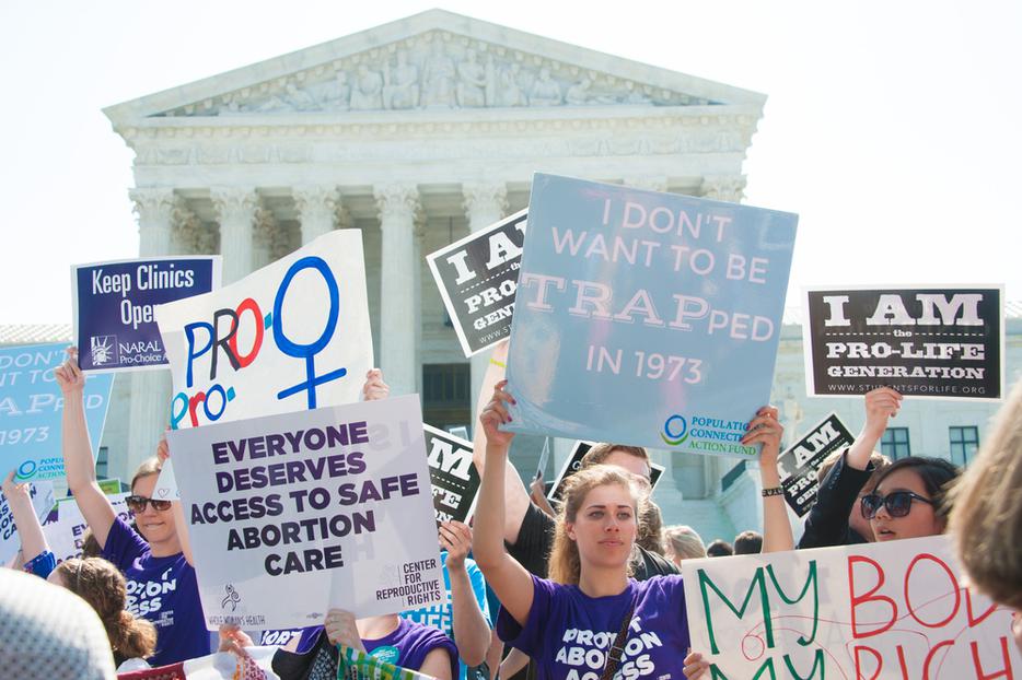 The pro-life community holds signs amid pro-abortion advocates awaiting the Supreme Court's ruling on abortion access in front of the Supreme Court in Washington, DC on June 27, 2016 The pro-life community holds signs amid pro-abortion advocates awaiting the Supreme Court's ruling on abortion access in front of the Supreme Court in Washington, DC on June 27, 2016