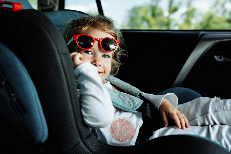 Young girl smiles sitting in her car seat. Young girl smiles sitting in her car seat.