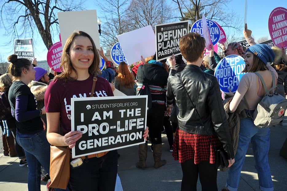 A young woman holds a pro-life sign near the US Supreme Court during the March For Life. A young woman holds a pro-life sign near the US Supreme Court during the March For Life.