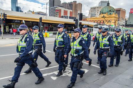 Victoria Police officers marching in formation along Swanston Street, between Flinders Street Station and Federation Square. Victoria Police officers marching in formation along Swanston Street, between Flinders Street Station and Federation Square.