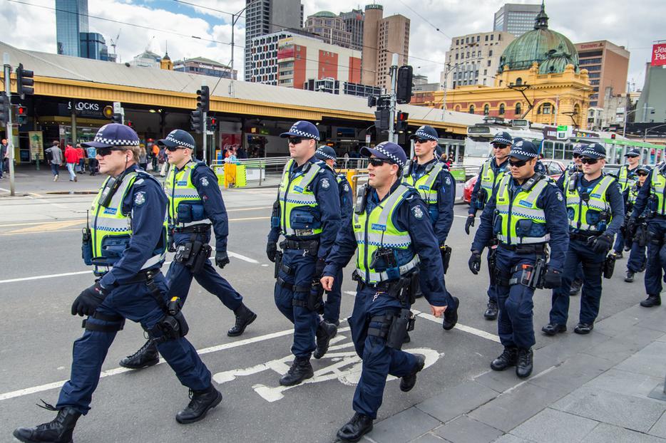 Victoria Police officers marching in formation along Swanston Street, between Flinders Street Station and Federation Square. Victoria Police officers marching in formation along Swanston Street, between Flinders Street Station and Federation Square.