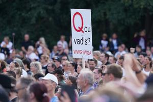 A QAnon supporter, holding a misspelled “Quo Vadis” sign, attends a rally protesting coronavirus-related restrictions at the Victory Column in Berlin, Germany, on Aug. 29. A QAnon supporter, holding a misspelled “Quo Vadis” sign, attends a rally protesting coronavirus-related restrictions at the Victory Column in Berlin, Germany, on Aug. 29.