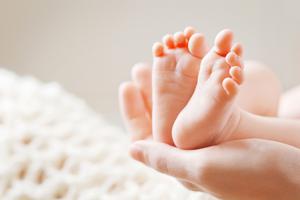 Mother holds baby's feet in her hands. Mother holds baby's feet in her hands.