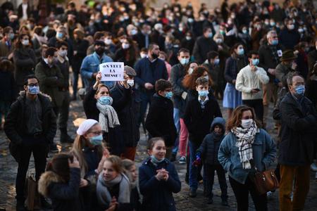 A woman holds a placard reading "We want the mass" as faithful Catholics rally to protest against COVID-19 restrictions under which masses are banned in churches, on November 15, 2020 in Versailles, outside Paris, as France is on a second lockdown to tackle the spread of the Covid-19 pandemic caused by the novel coronavirus.