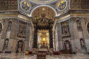 The interior of St. Peter's Basilica in Vatican City with a Baroque canopy over the altar. The interior of St. Peter's Basilica in Vatican City with a Baroque canopy over the altar.