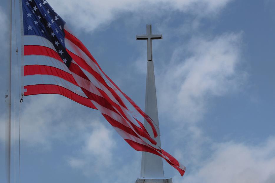 American Flag waving in front of church steeple. American Flag waving in front of church steeple.